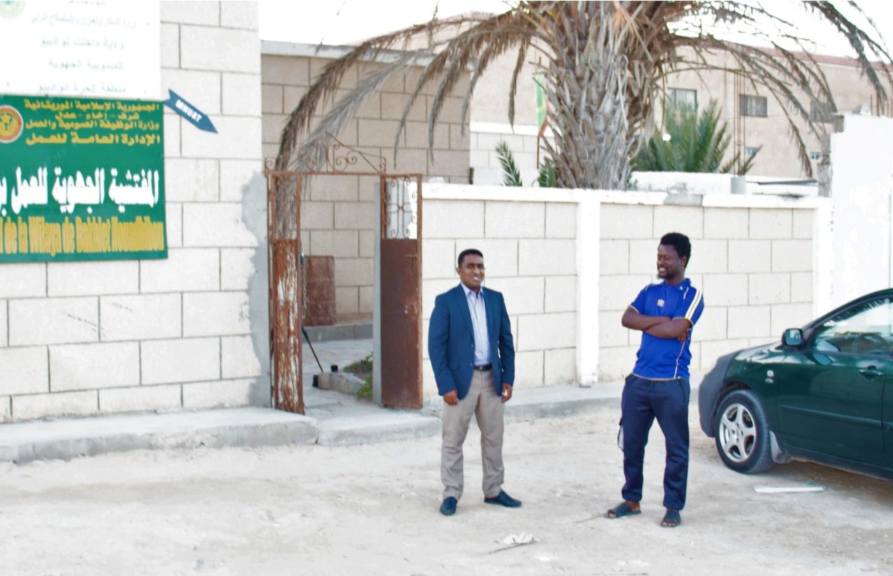 Mohamed Khatri, a labour inspector in Mauritania, speaks with a colleague before going inside for work.