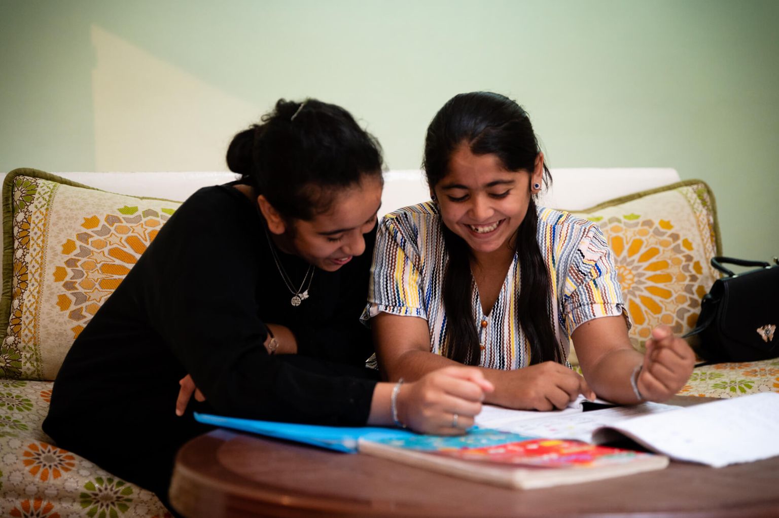 Ghizlan is studying with her friend in her house.