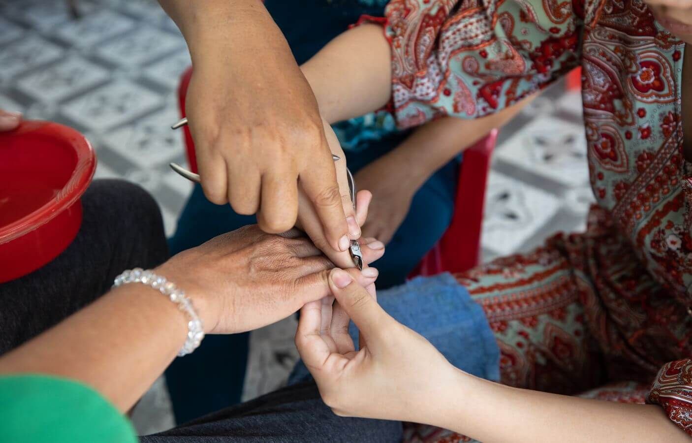 A salon owner guides Ngan on how to care for nails during her vocational training.