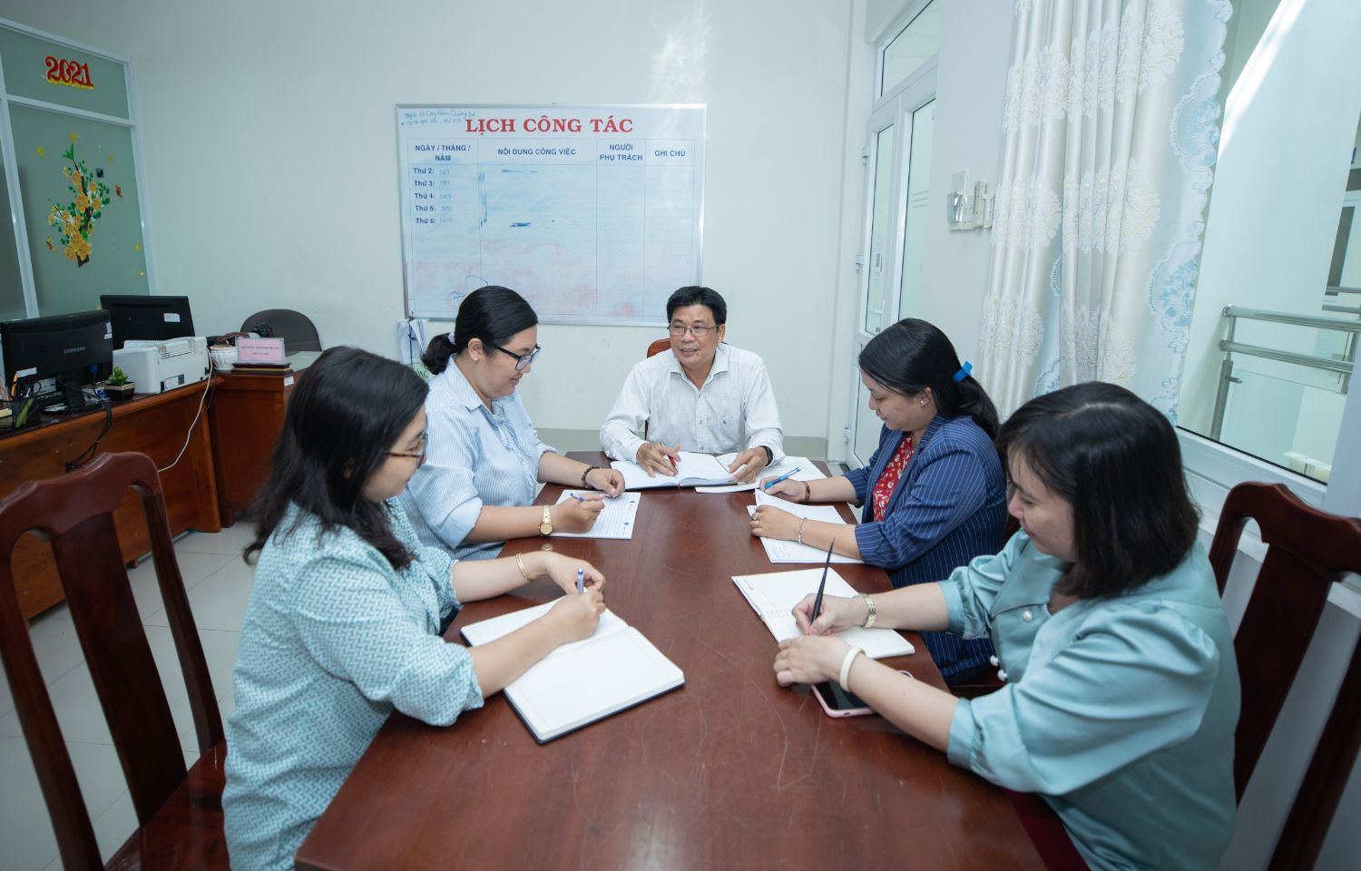 Mr. Chau meets with his colleagues on the monthly work plan for the ENHANCE project.